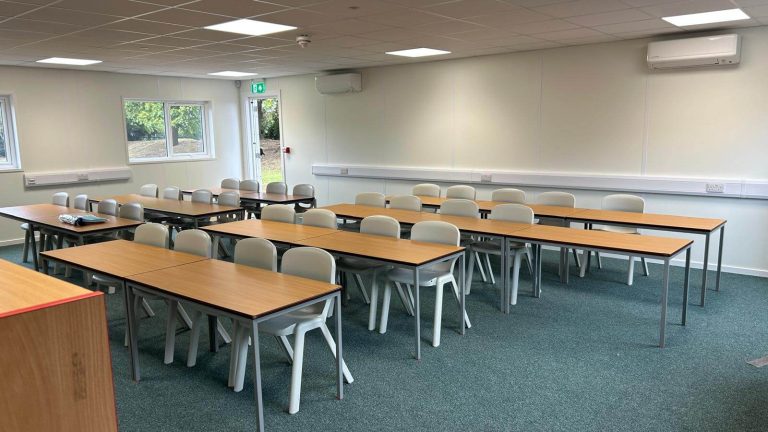 Inside the new Advantage Schools modular classroom with desks, blinds and air conditioning